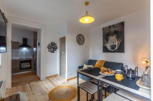 un salon avec une table de salle à manger et une cuisine dans l'établissement Refuge de l'ours : T2 équipé avec parking et wifi, à Bagnères-de-Bigorre