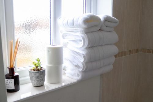 ein Haufen Handtücher auf einem Fensterbrett in der Unterkunft Beautiful Oxford Townhouse near City Centre in Oxford