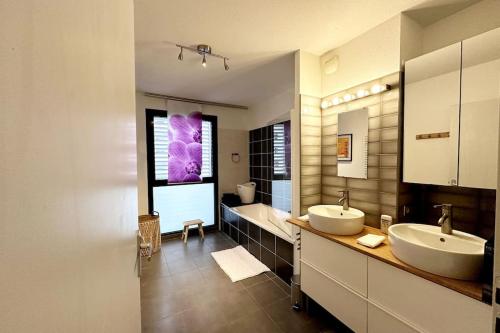 La grande salle de bains est pourvue de 2 lavabos et d'une baignoire. dans l'établissement Bel Appart Design 2ch, Mairie, Pkg, Wifi, Terrasse, Port Marianne, à Montpellier