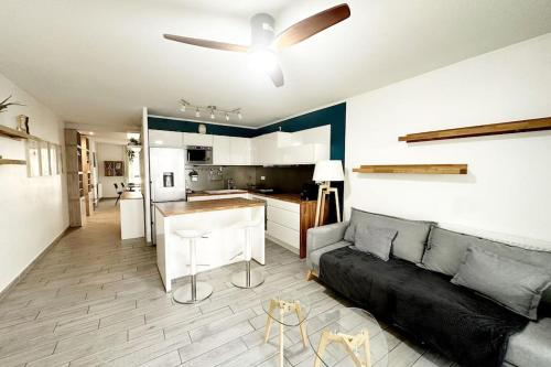 un salon avec un canapé et un ventilateur de plafond dans l'établissement Bel Appart Design 2ch, Mairie, Pkg, Wifi, Terrasse, Port Marianne, à Montpellier