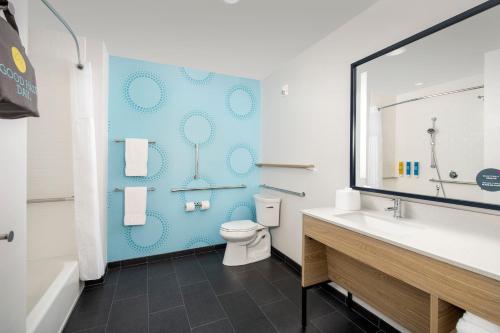 a bathroom with a toilet and a blue wall at Tru By Hilton Jacksonville Airport in Jacksonville