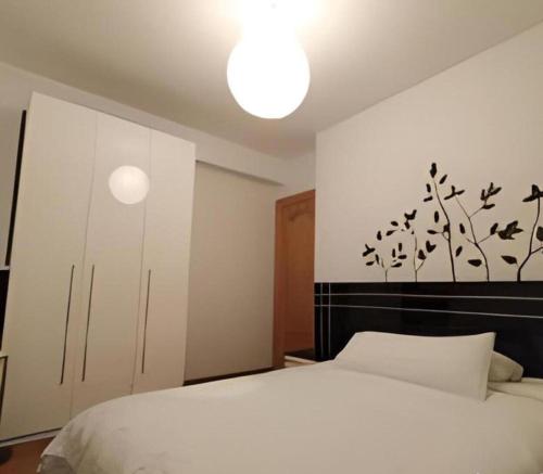 1 dormitorio con cama blanca y cabecero negro en Balcón de Ezcaray MTB terraza y montaña, en Zorraquín