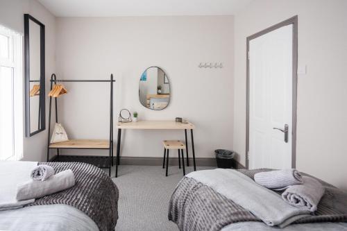 - 2 lits dans une chambre avec un miroir et un bureau dans l'établissement Belfast Townhouse, à Belfast