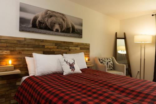 a bedroom with a bed with a bear picture on the wall at Condo Hotel Au pied du Mont Orford in Orford