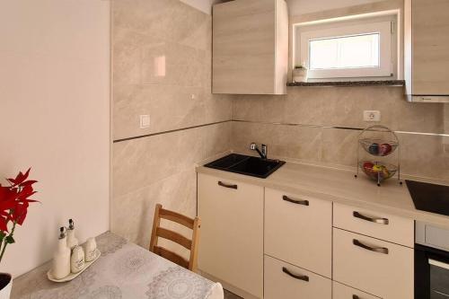 a small kitchen with a sink and a table at Cozy apartment under the vine in Sežana