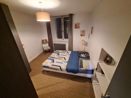 een kleine slaapkamer met een bed en een raam bij Charmant T2 avec vue sur le port et parking in Vannes
