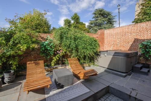 a patio with two chairs and a hot tub at Executive Suite with Private Hot Tub SkyTV in Saffron Walden