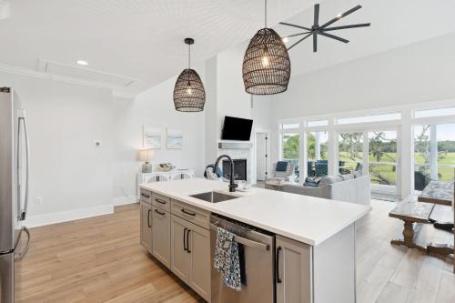 a kitchen and living room with white walls and windows at Champagne and Sunsets in Edisto Island