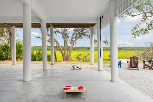 a large white pavilion with a table and chairs at Champagne and Sunsets in Edisto Island