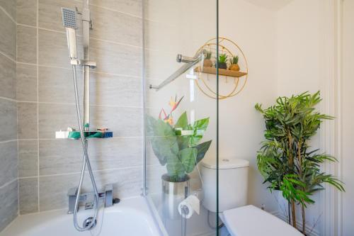 La salle de bains est pourvue d'une douche, de toilettes et de plantes. dans l'établissement Charming 1-Bed House in London, à Londres