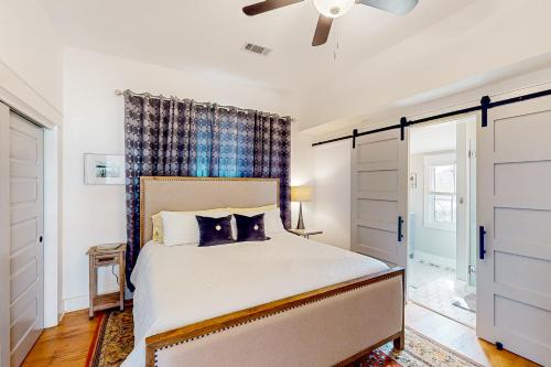 um quarto com uma cama e uma ventoinha de tecto em Pensacola Blue em Pensacola