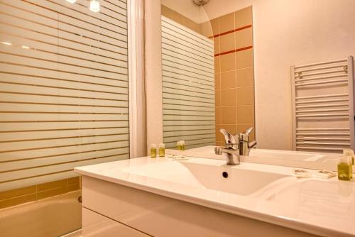 une salle de bain avec un lavabo, une baignoire et un miroir dans l'établissement Cottage Charme et Champêtre 6P, à Auberville