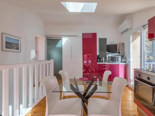 a dining room with a glass table and white chairs at Opuntia Teouliero location en Méditerranée in Escales