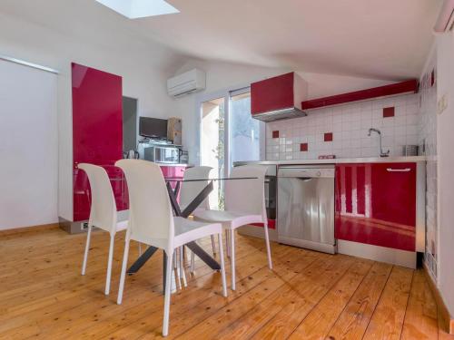 une cuisine avec une table en verre et des chaises blanches dans l'établissement Opuntia Teouliero location en Méditerranée, à Escales