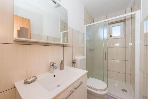 a bathroom with a sink and a toilet and a shower at Apartment Ante in Vodice