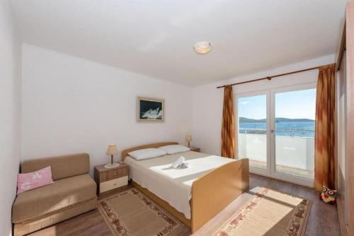 a bedroom with a bed and a couch and a window at Apartment Ante in Vodice