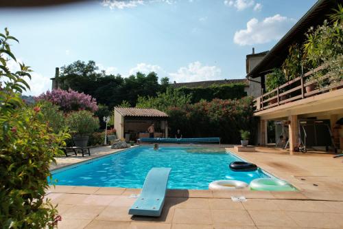 a swimming pool in a yard with a house at Gîte 3 "le Canal de Baza" aux Magnolias in Aubenas