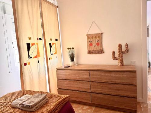 a bedroom with a wooden dresser and a cactus at Casa de Mila in Alicante