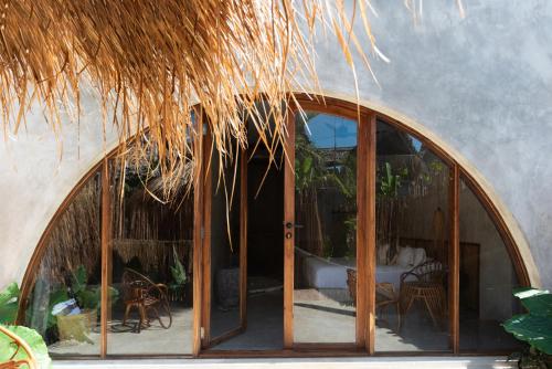 a large glass doorway to a patio with a thatch roof at Be Zanzibar Boutique Hotel in Mfumbwi