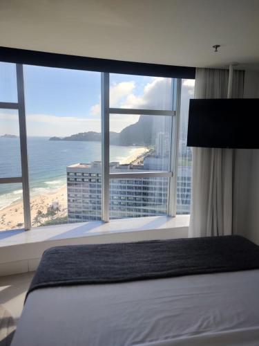 a bedroom with a bed and a view of the ocean at Hotel Nacional in Rio de Janeiro