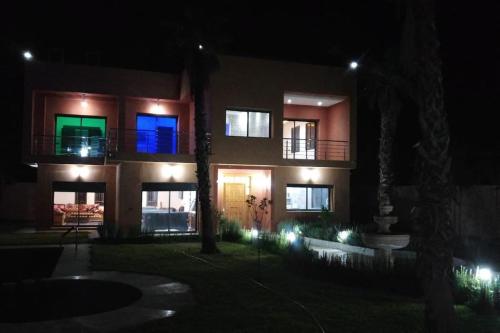 a building with blue and green windows at night at Villa isouktan in Sbiti