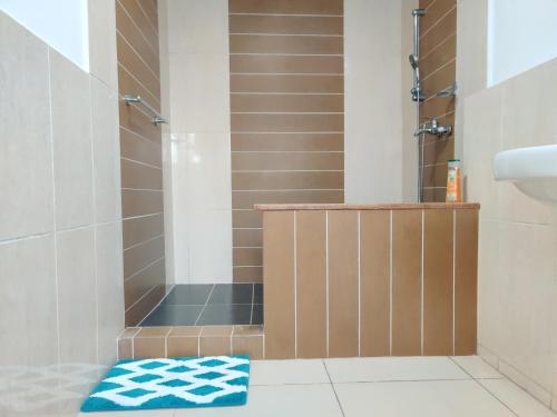 łazienka z prysznicem i niebieskim ręcznikiem na podłodze w obiekcie Beach Road Oasis w mieście Sekondi-Takoradi