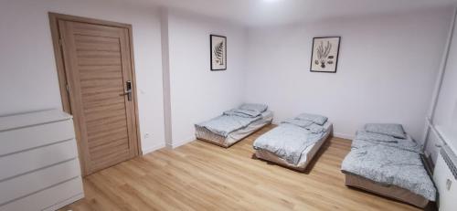 a room with two beds and a door at Apartament Wojska Polskiego in Starachowice