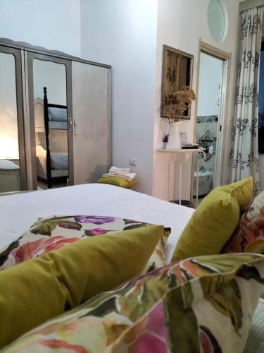 a bedroom with a bed with green pillows at Carru de ammentos in Ozieri