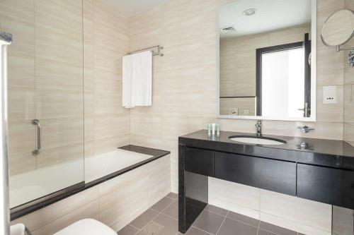 a bathroom with a sink and a shower and a mirror at Frank Porter - Damac Celestia in Dubai