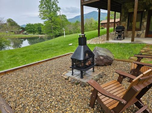 una chimenea en un patio trasero con mesa de picnic y bancos en Mallard's Nest cabin, en Sevierville