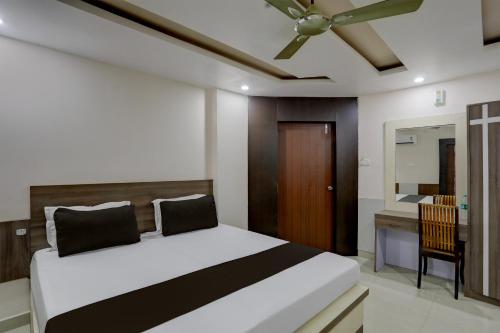 1 dormitorio con 1 cama y ventilador de techo en OYO Anusuya Hotel en Bhubaneshwar