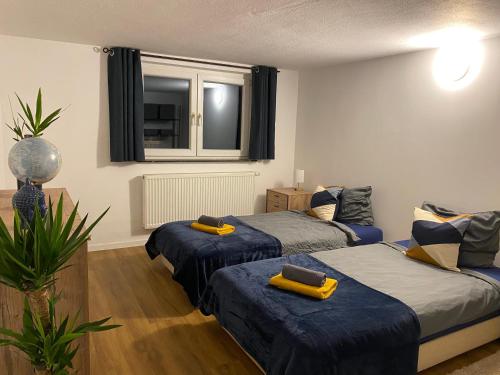 a room with two beds and a window at Apartment Roomy Comfort - Zwischen Heidelberg und Mannheim in Edingen-Neckarhausen