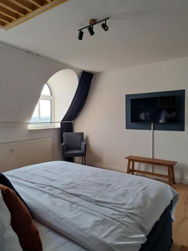 a bedroom with a large bed and a window at LIVORA Altstadt Wilhelmshaven - Stilvoll - Zentrumsnah - TV-Streaming - Balkon - Nordsee - Badewanne in Wilhelmshaven