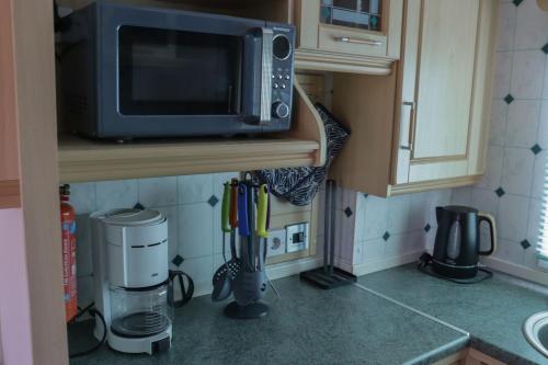 a kitchen with a microwave on a counter next to a counter at Kom heerlijk tot rust in Casa Debonair in Peperga