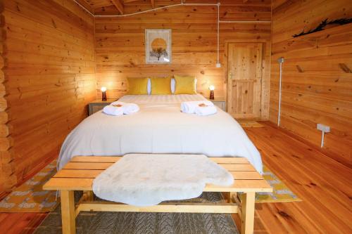 1 dormitorio con 1 cama en una cabaña de madera en Reindeer Lodge by StayStaycations 