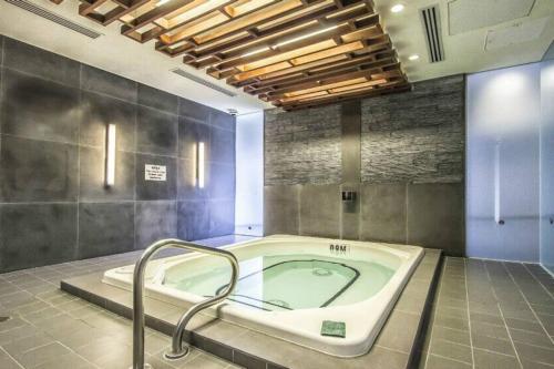 ein Bad mit einer Badewanne in einem Zimmer in der Unterkunft Rare 1BR - Rooftop Pool, Next to MTCC & CN Tower in Toronto