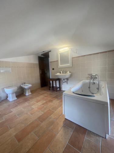 y baño con bañera, aseo y lavamanos. en LocAle Guest House, en Pietralunga