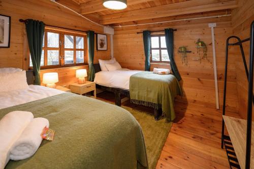 1 dormitorio con 2 camas en una cabaña de madera en Reindeer Lodge by StayStaycations 