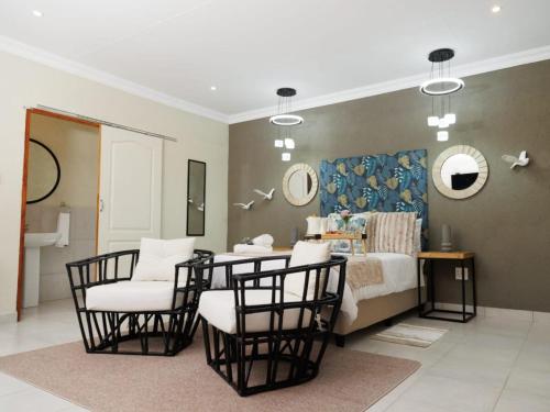 a bedroom with a table and chairs and a bed at Lions View Accommodation in Nelspruit