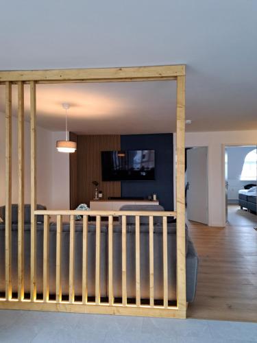 a room with a crib and a living room at LIVORA Altstadt Wilhelmshaven - Stilvoll - Zentrumsnah - TV-Streaming - Balkon - Nordsee - Badewanne in Wilhelmshaven