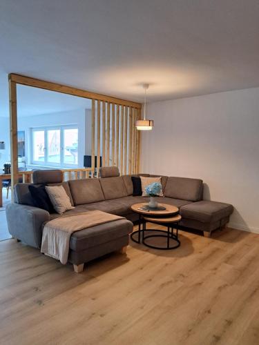 a living room with a couch and a table at LIVORA Altstadt Wilhelmshaven - Stilvoll - Zentrumsnah - TV-Streaming - Balkon - Nordsee - Badewanne in Wilhelmshaven