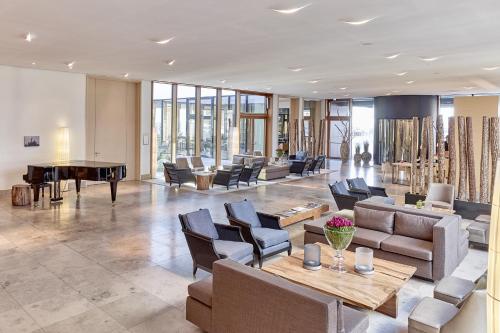 BUDERSAND Hotel - Golf & Spa - Sylt في هورنوم: لوبي فيه كنب وطاولة بينج بونج
