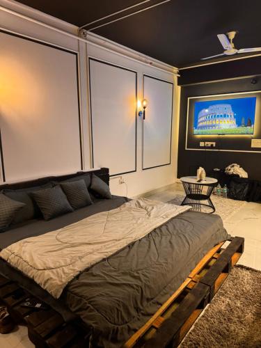 een slaapkamer met een groot bed en een flatscreen-tv bij BnW studio - Cozy & Complete in Ghaziabad