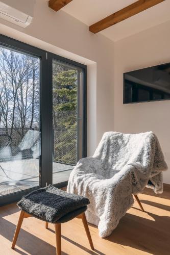 a bedroom with a chair and a large window at Mátra Zenit in Mátraszentimre