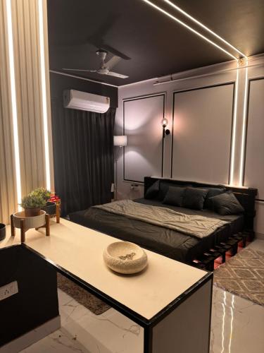 een slaapkamer met een bed en een tafel met een hoed erop bij BnW studio - Cozy & Complete in Ghaziabad
