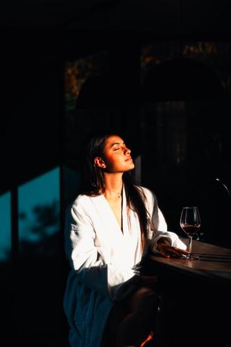 a woman sitting at a table with a glass of wine at The Boato Hotel in Guatapé