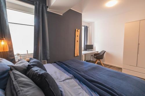 a bedroom with a bed and a desk and a window at TANIC Deluxe Apartment Garden Central Industrial Fair in Düsseldorf