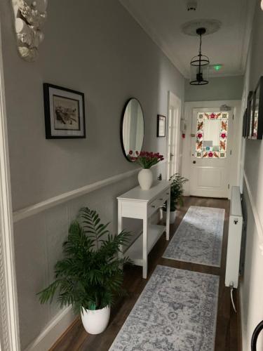 a hallway with a mirror and a table with plants at The Old Coach House in Blackpool