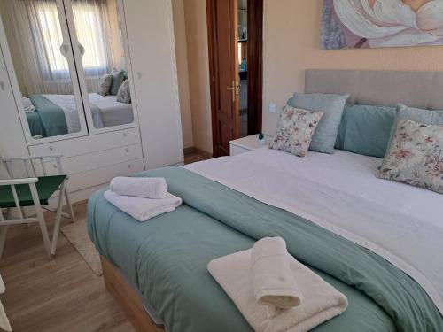 a bedroom with a bed with towels on it at Mi casita del norte in Mogro
