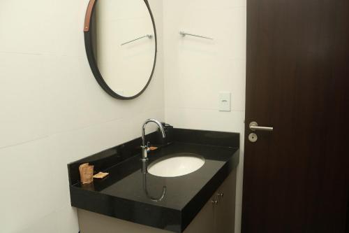 a bathroom with a sink and a mirror at Edificio Liv P.Verde Apto 906-Mandi Hospitalidade in Maceió